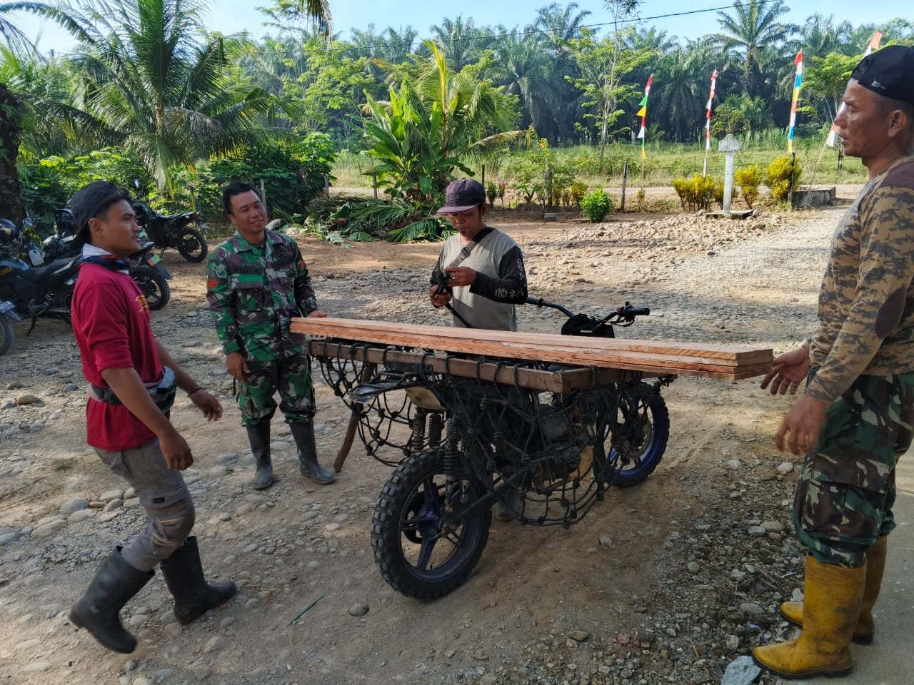 Warga Angkut Papan untuk Bekisting Bersama Satgas TMMD Gunakan Sepeda Motor