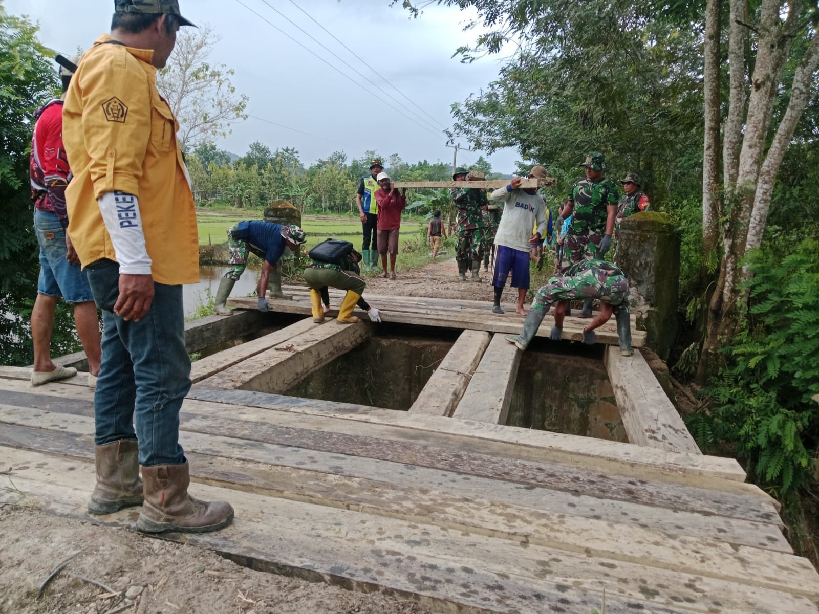 TNI, Warga dan Polri Kompak Pasang Lantai Jembatan di Awua Jaya dalam Program TMMD 125