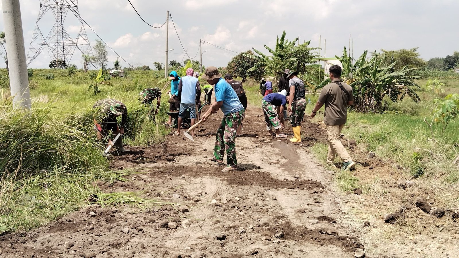 Wujud Kemanunggalan, TNI dan Masyarakat Slempit Gotong Royong Ratakan Jalan Desa di Lokasi TMMD